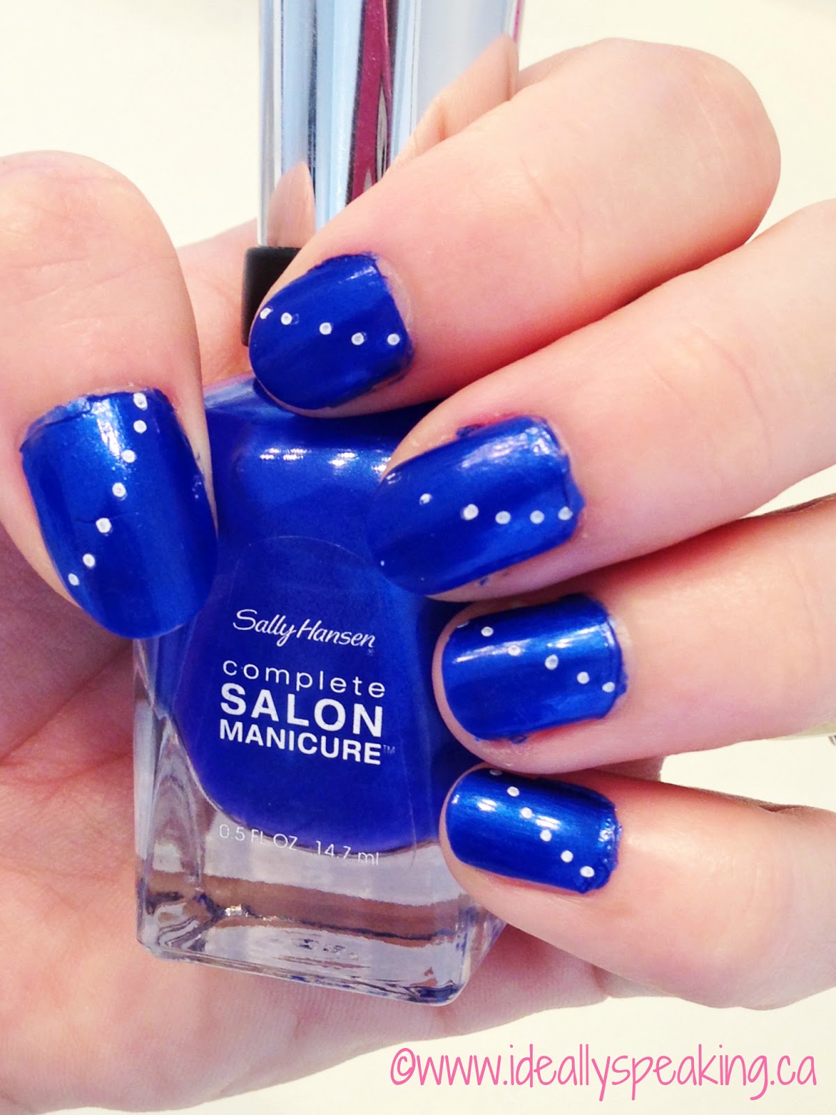 Electric blue nails with white polka dots. 